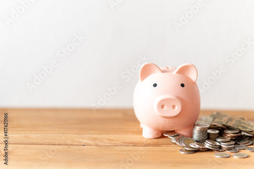 piggy bank with coin on the wood table photo