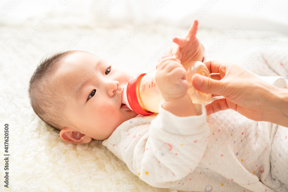 哺乳瓶を咥えてミルクを飲んでいる赤ちゃん 哺乳瓶を咥えてミルクを飲んでいる赤ちゃん