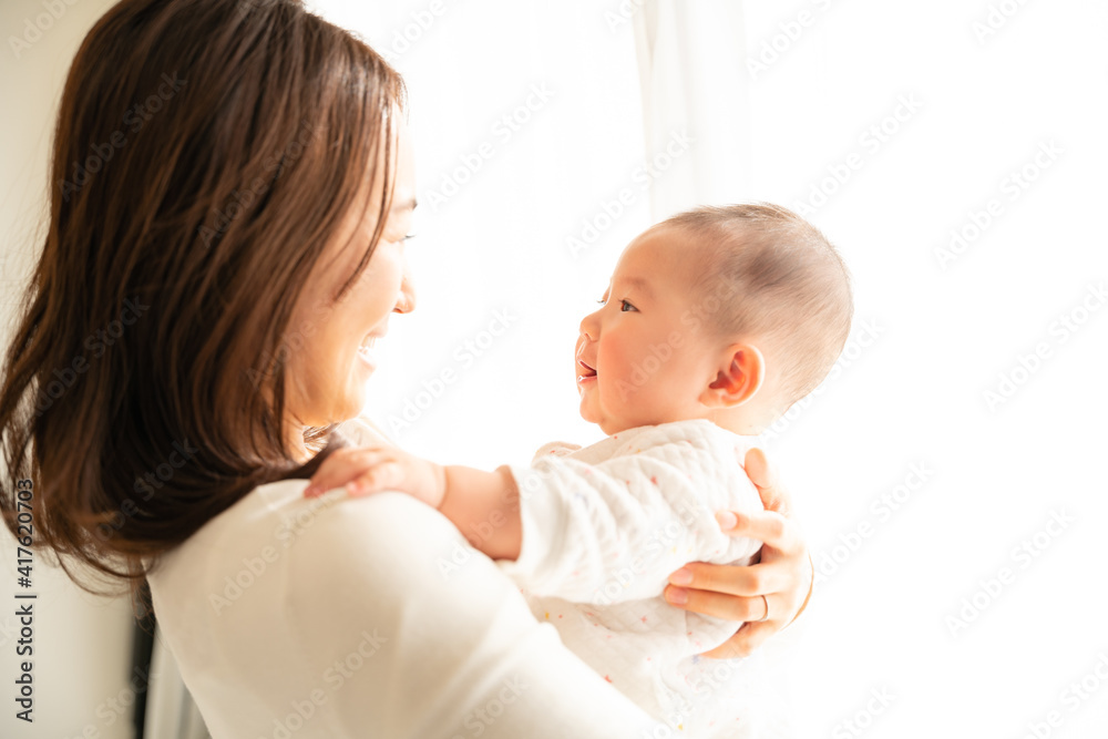 お母さんと向かい合って抱っこされている赤ちゃん Stock Foto Adobe Stock