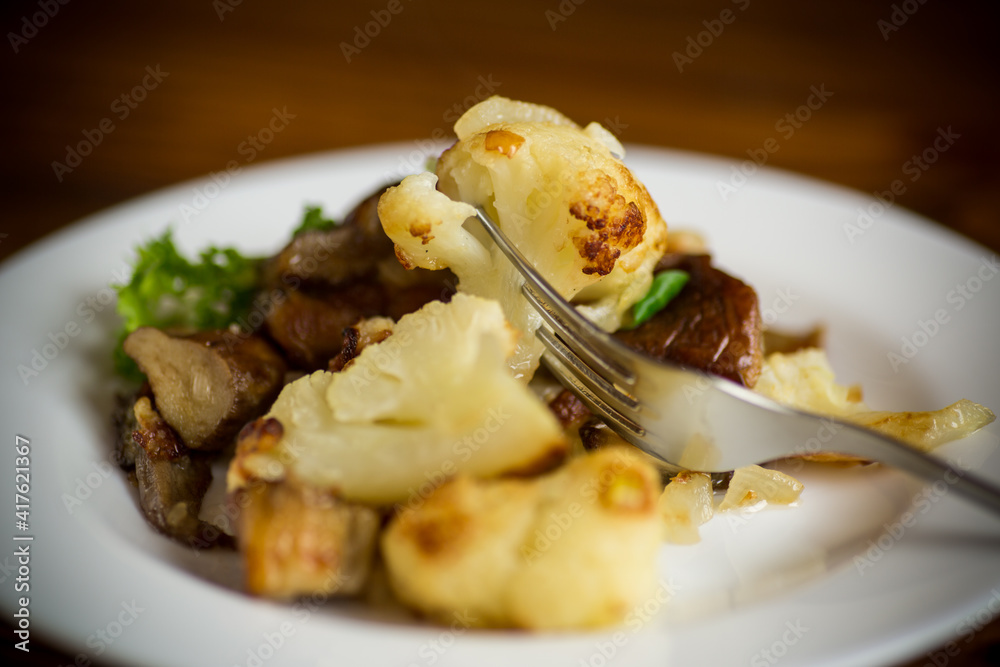 fried cauliflower with wild porcini mushrooms and onions in a plate fried cauliflower with wild porcini mushrooms and onions in a plate