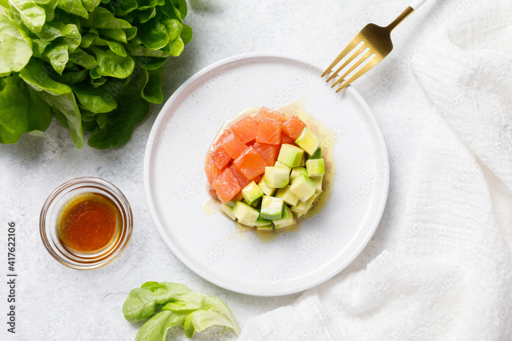 Salmon avocado tartare on white stone table background. Flat lay, top view