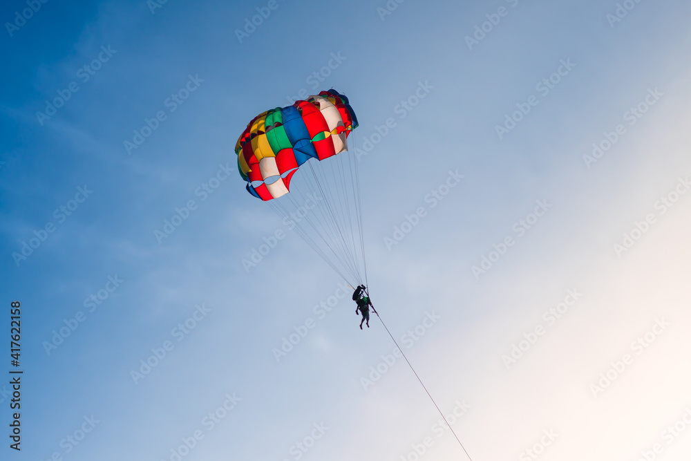 Parasailing in blue sky. Sports, active leisure, travel, vacation concept Parasailing in blue sky. Sports, active leisure, travel, vacation concept