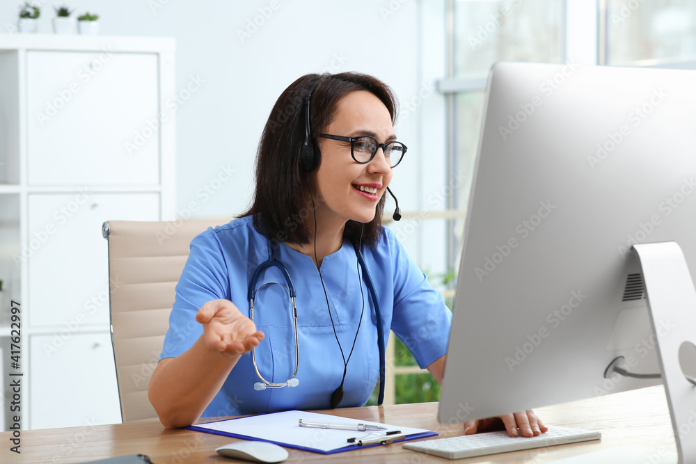 Doctor with headset and computer consulting patient online in office. Hotline service Doctor with headset and computer consulting patient online in office. Hotline service