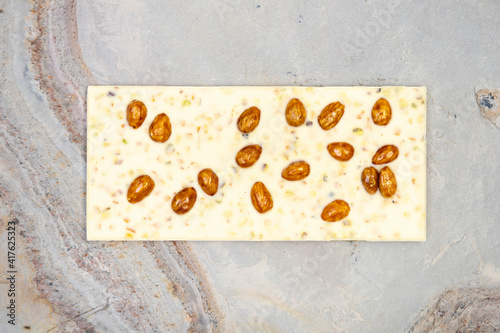 Sweet and delicious whole chocolate bar lies on light stone background photo taken from above in studio