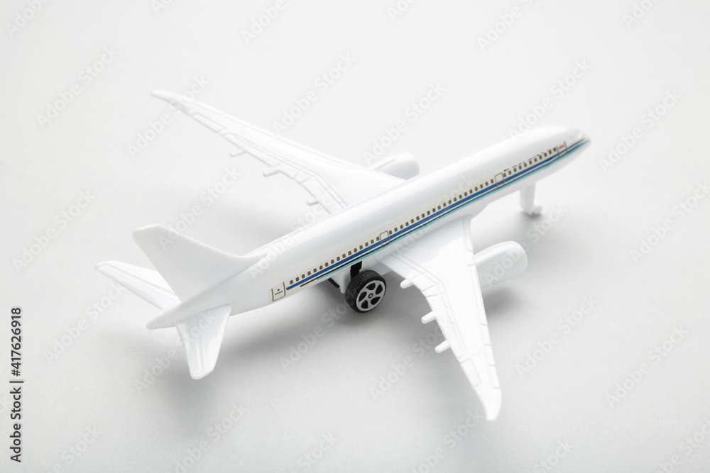 Model white airplane on a grey background.