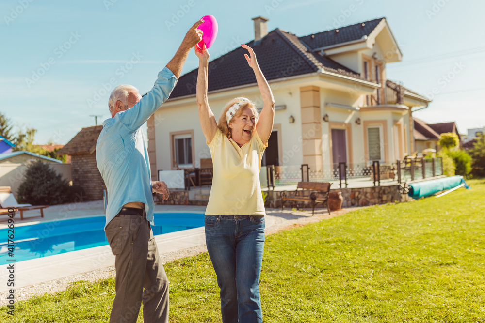 Obraz premium Senior couple having fun playing toss and catch