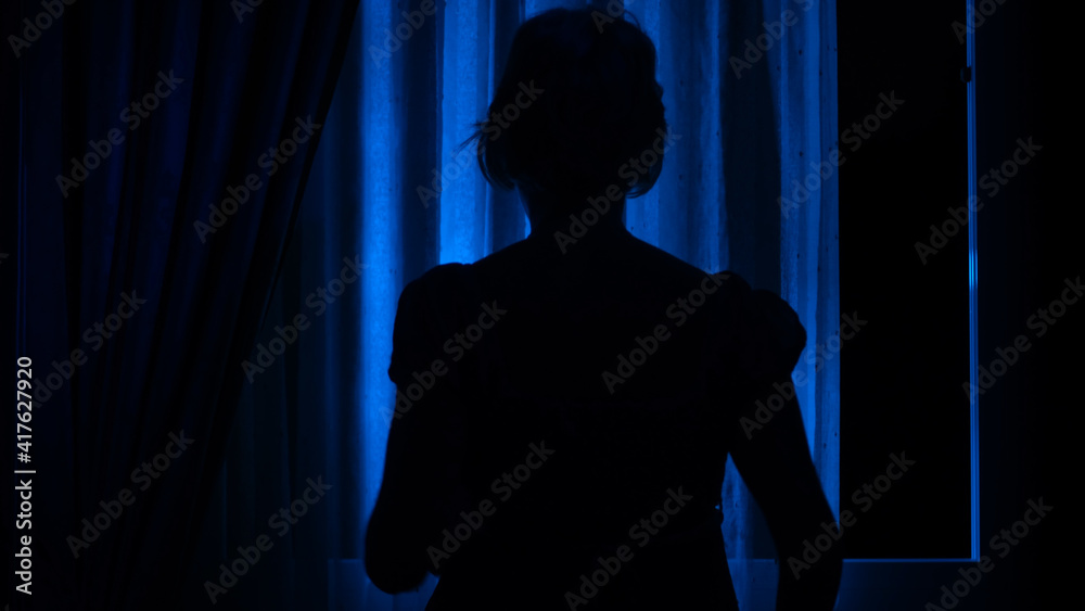 Blue window. Window with a woman. Halloween. Scary woman. Blue window with a woman.  Wind in the window. Horror. Fear. Dark window. Dark. 
