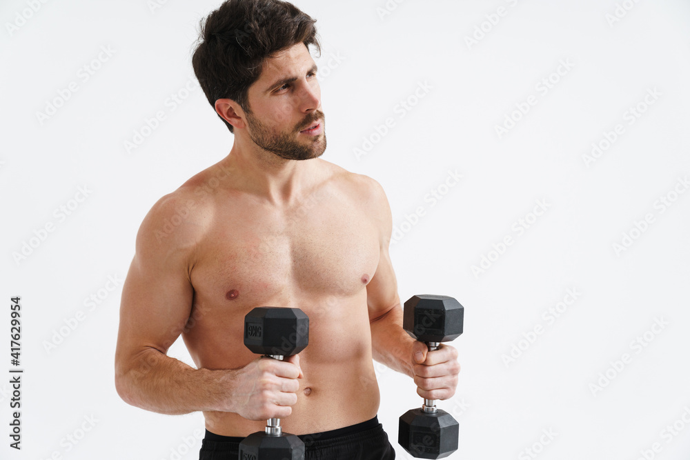Half-naked athletic sportsman working out with dumbbells Half-naked athletic sportsman working out with dumbbells