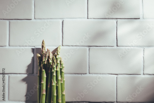 Fresh green asparagus on white tiles