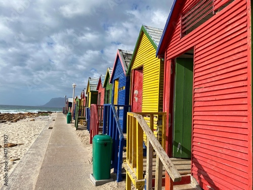 Colorful beach huts on a cloudy day at St James beach in Cape Town © Fables Collective