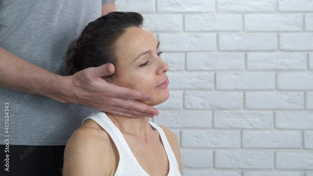 Females do neck massage. Neck massage. The man holds the woman's head in his hands and leans in different directions. Females do neck massage. Neck massage. The man holds the woman's head in his hands and leans in different directions.