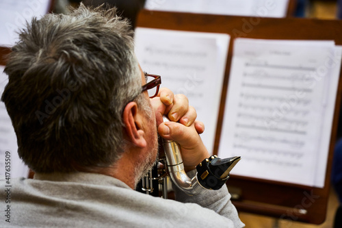 Photos Saxophonist's hands resting on the trumpet during a break in the rehearsal