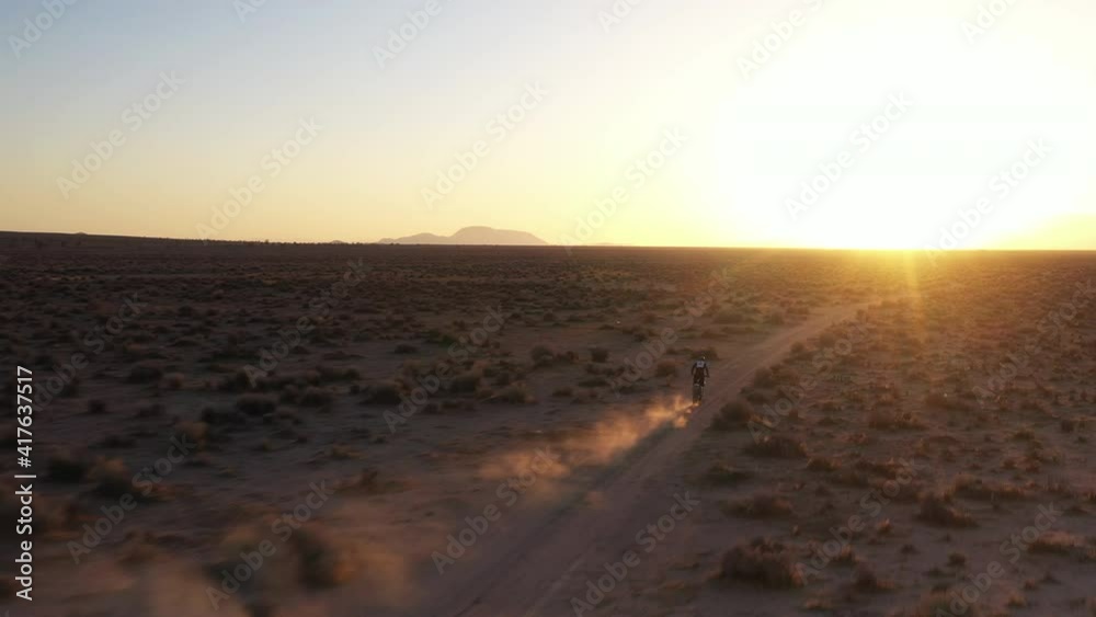 Following a motorcycle in the Mojave Desert at sunset - aerial tracking view Following a motorcycle in the Mojave Desert at sunset - aerial tracking view