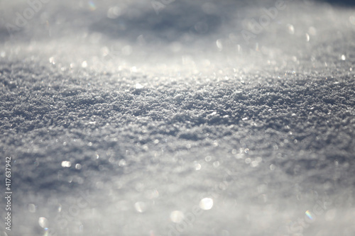 Snow close-up, winter background with copy space, glittering snowflakes with bokeh.