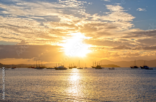  Sunset on a tropical beach with pirate boats in the background , located on the beach of Cachoeira do Bom Jesus, Canasvieras, Ponta das Canas, Florianopolis, Santa Catarina, Brazil