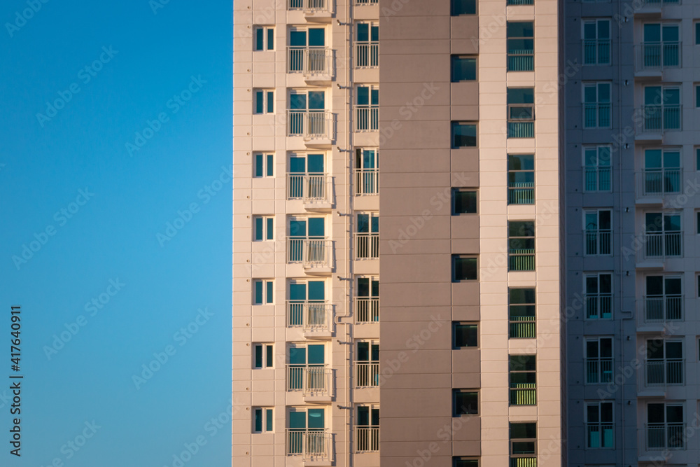 Part of an apartment tower against blue sky