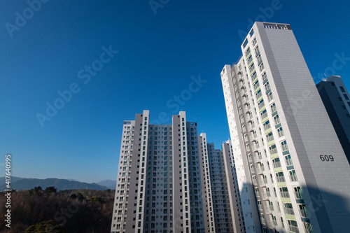 Low angle view of an apartment tower in front of a blue sky in South Korea