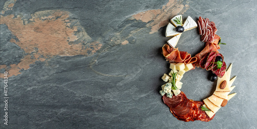 Italian appetizers or antipasto set with gourmet food on stone table. Mixed cheese and meat snacks of the number eight. International Women's Day. Long banner format, top view