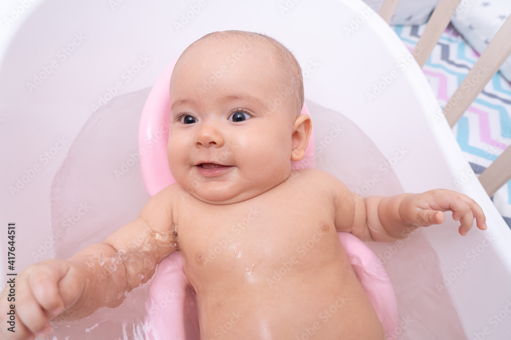Happy newborn baby bathes in the bathroom. Top view Happy newborn baby bathes in the bathroom. Top view