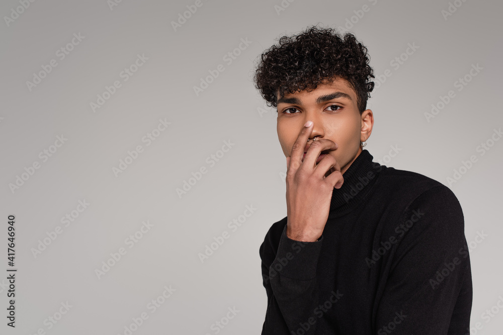 young african american man in turtleneck sweater covering face isolated on grey young african american man in turtleneck sweater covering face isolated on grey