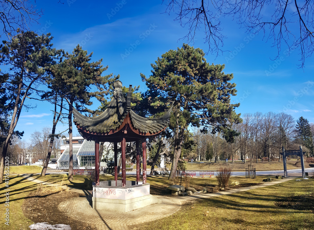 Beautiful Kronvalda park with China gazebo along a frozen Riga canal in sunny day. Riga. Latvia