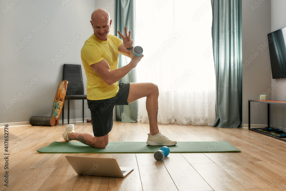 Trainer leading a workout with dumbbells Trainer leading a workout with dumbbells