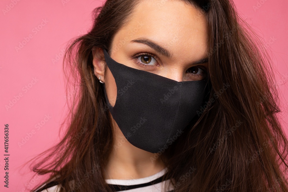 Closeup shot of of young fascinating woman wearing mediacal face mask isolated over background wall. Protection against COVID-19 Closeup shot of of young fascinating woman wearing mediacal face mask isolated over background wall. Protection against COVID-19