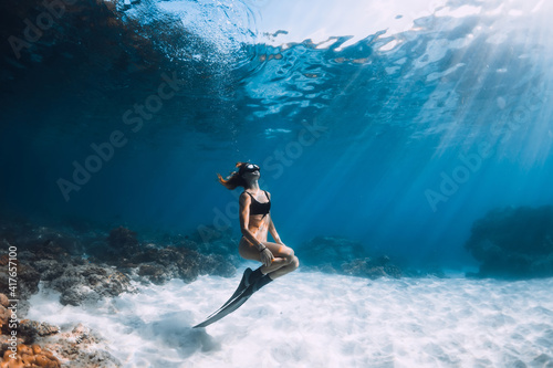 Woman freediver posing over sandy sea. Freediving underwater in Hawaii