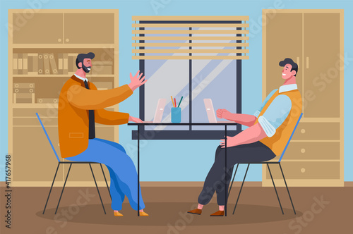Businessmen dressed in casual clothes are sitting at the table with laptops and talking. Office workers discussing project. Business meeting and consideration of working moments. Friendly team work