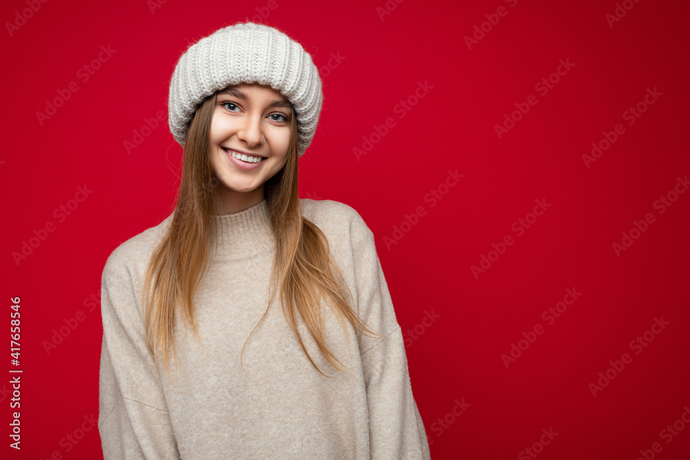 Attractive smiling happy young dark blond woman standing isolated over colorful background wall wearing everyday stylish outfit showing facial emotions looking at camera