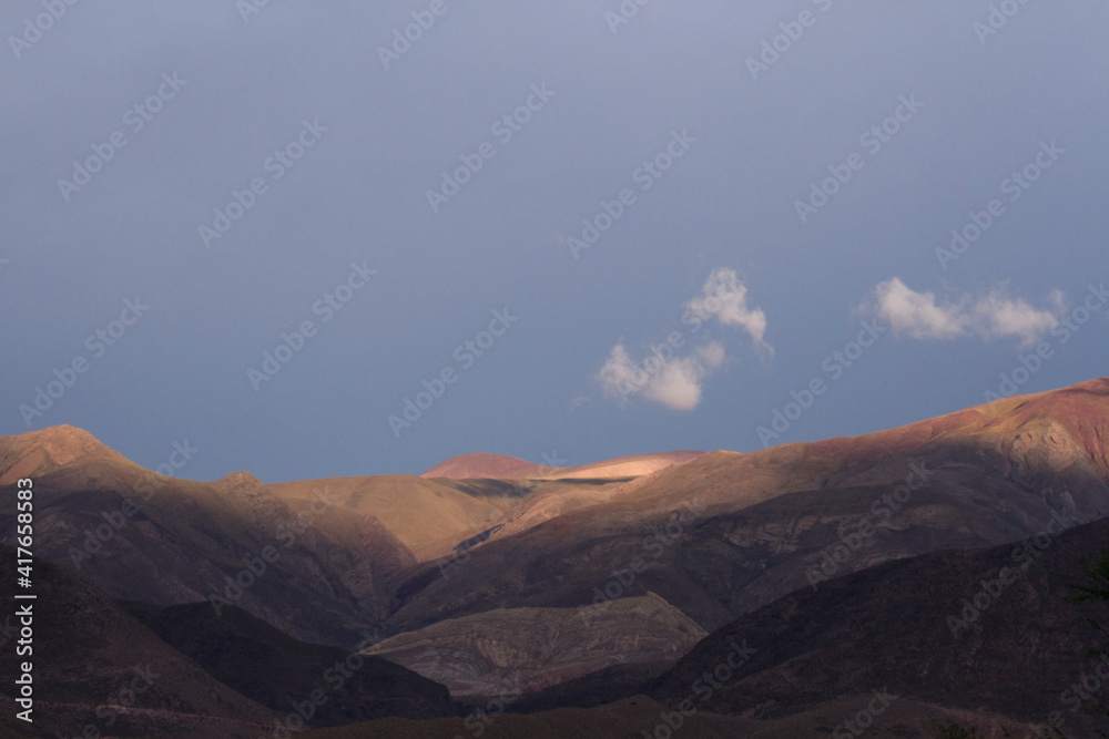 Fototapeta premium Alpine landscape. The Andes mountains at sunrise. Aerial view of the arid mountains under a blue sky at dawn.