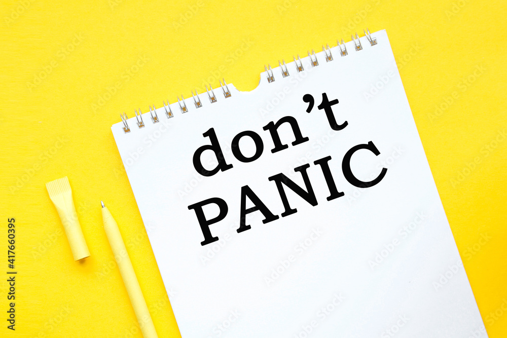 DONT PANIC inscription on white list, yellow pen on a yellow background. a bright solution for business, financial, marketing concept DONT PANIC inscription on white list, yellow pen on a yellow background. a bright solution for business, financial, marketing concept