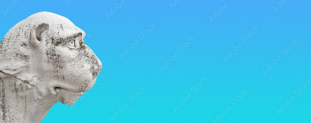 Obraz premium Banner with ancient Venetian Piraeus lion head near Arsenal in Venice with copy space for text and gradient sky background, Italy, closeup, details. Concept art and historical places heritage.