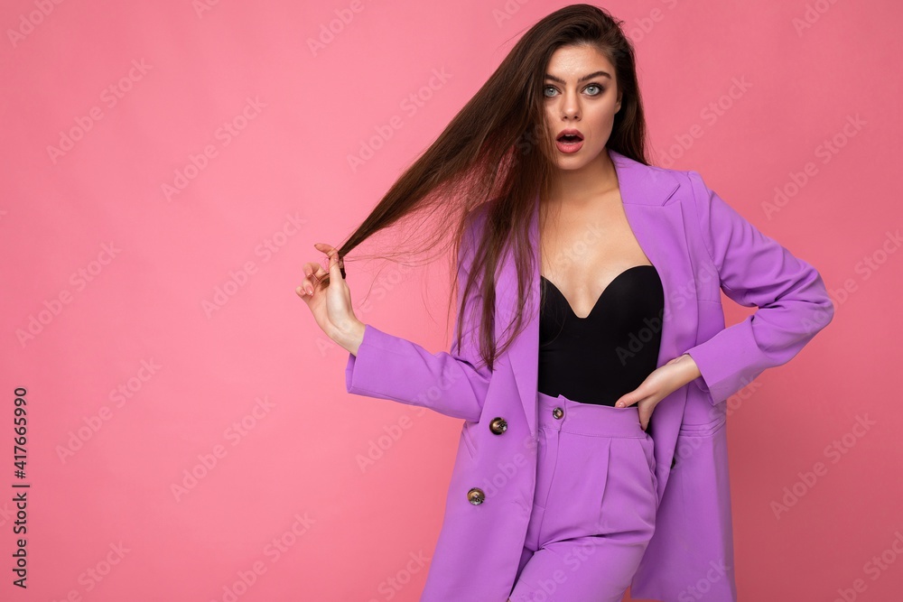 Portrait of surprised amazed beautiful fashionable brunette woman in casual trendy violet jacket isolated on pink background with free space. Shock concept Portrait of surprised amazed beautiful fashionable brunette woman in casual trendy violet jacket isolated on pink background with free space. Shock concept