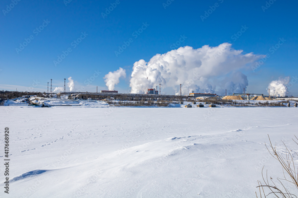 Obraz premium A large industrial complex against the backdrop of a bright blue sky.