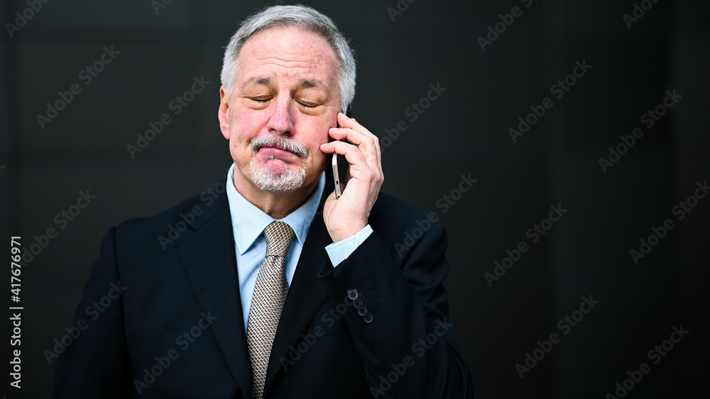 Senior manager on the phone looking disappointed or upset Senior manager on the phone looking disappointed or upset