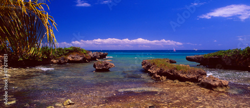 Guadeloupe: coastal landscape with rocks and a sailboat at Bas du Fort