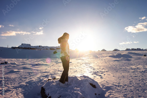 Woman hiking in the mountains in snow. Success at reaching the top. Happy emotions.