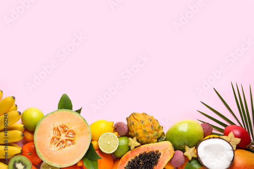 Different exotic fruits on light pink background  flat lay. Space for text