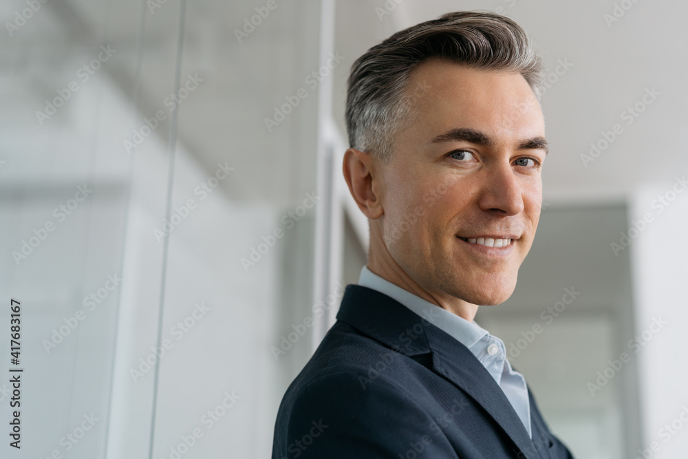 Closeup portrait of handsome mature businessman looking at camera in office. Successful business Closeup portrait of handsome mature businessman looking at camera in office. Successful business