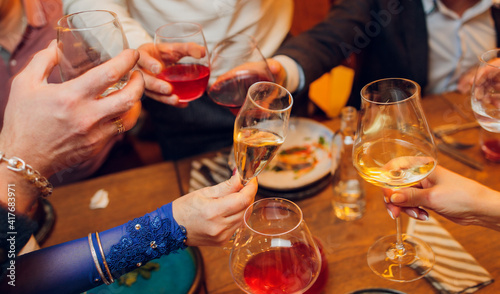 Obraz na plátně Clinking glasses with alcohol and toasting, party.