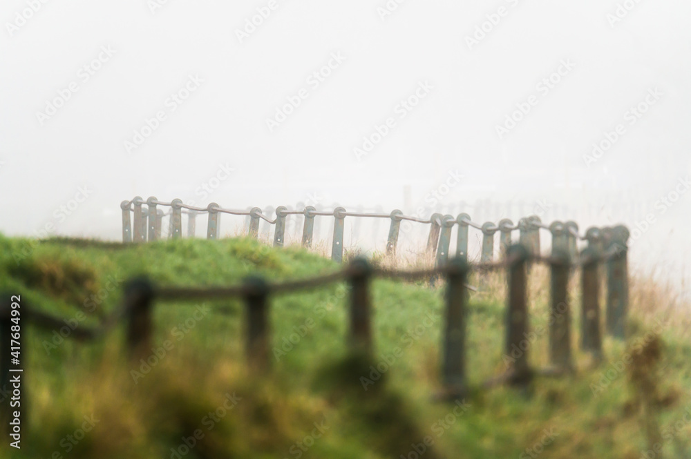 Photo of a fence in a field in fog, england