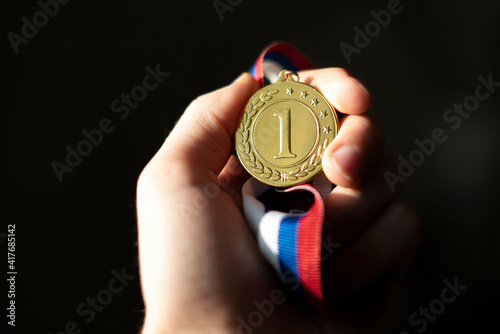 a campion's hand holding a golden medal, simple winner lucky concept