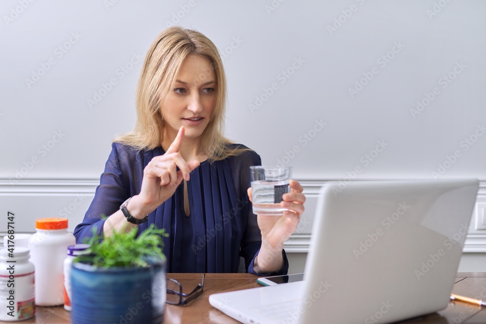 Nutritionology, female nutritionist consulting online,looking at laptop screen talking to patient Nutritionology, female nutritionist consulting online,looking at laptop screen talking to patient