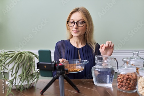 Activation of vitamins and minerals in nuts. Woman nutritionist soaking nuts in water photo