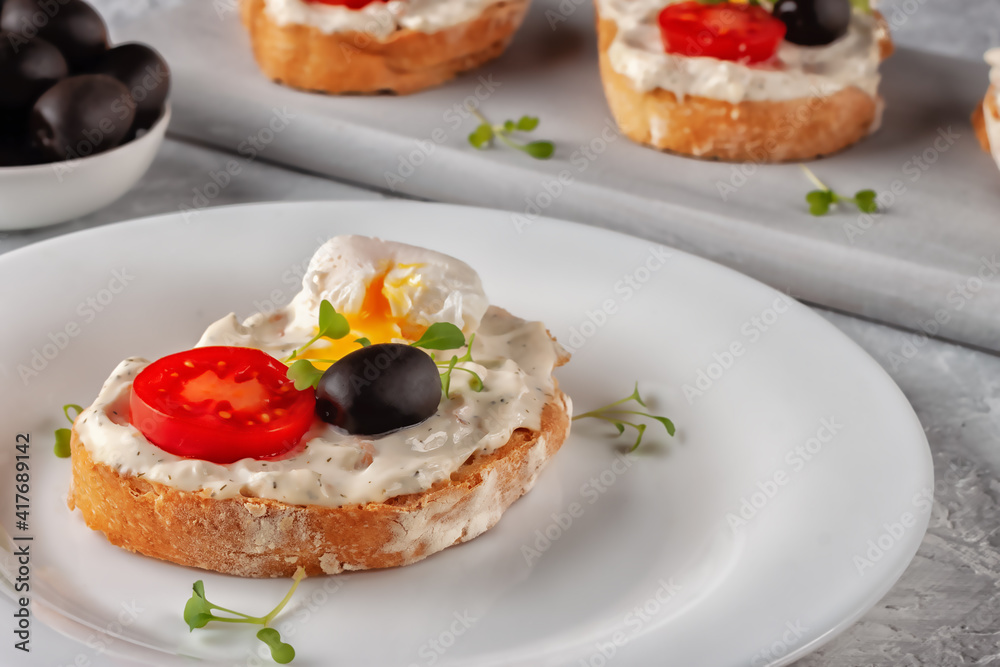 Bruschetta with tomato, olives and poached quail egg