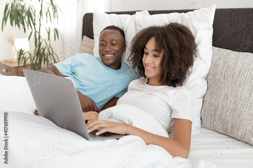 Enjoying online purchases and comfortable shopping in bed