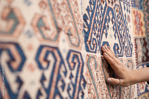 Tourist woman chooses Turkish rug at the bazaar.Traditional turkish rug shop. photo