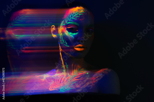 trendy neon makeup on the model. Woman with ultraviolet make-up. Disco night club chameleon. UV colors. Fashion of the future bright appearance. face Art. Copy space for text background