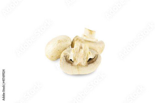 Three fresh champignons, one is cutted lengthwise, isolated on white background.